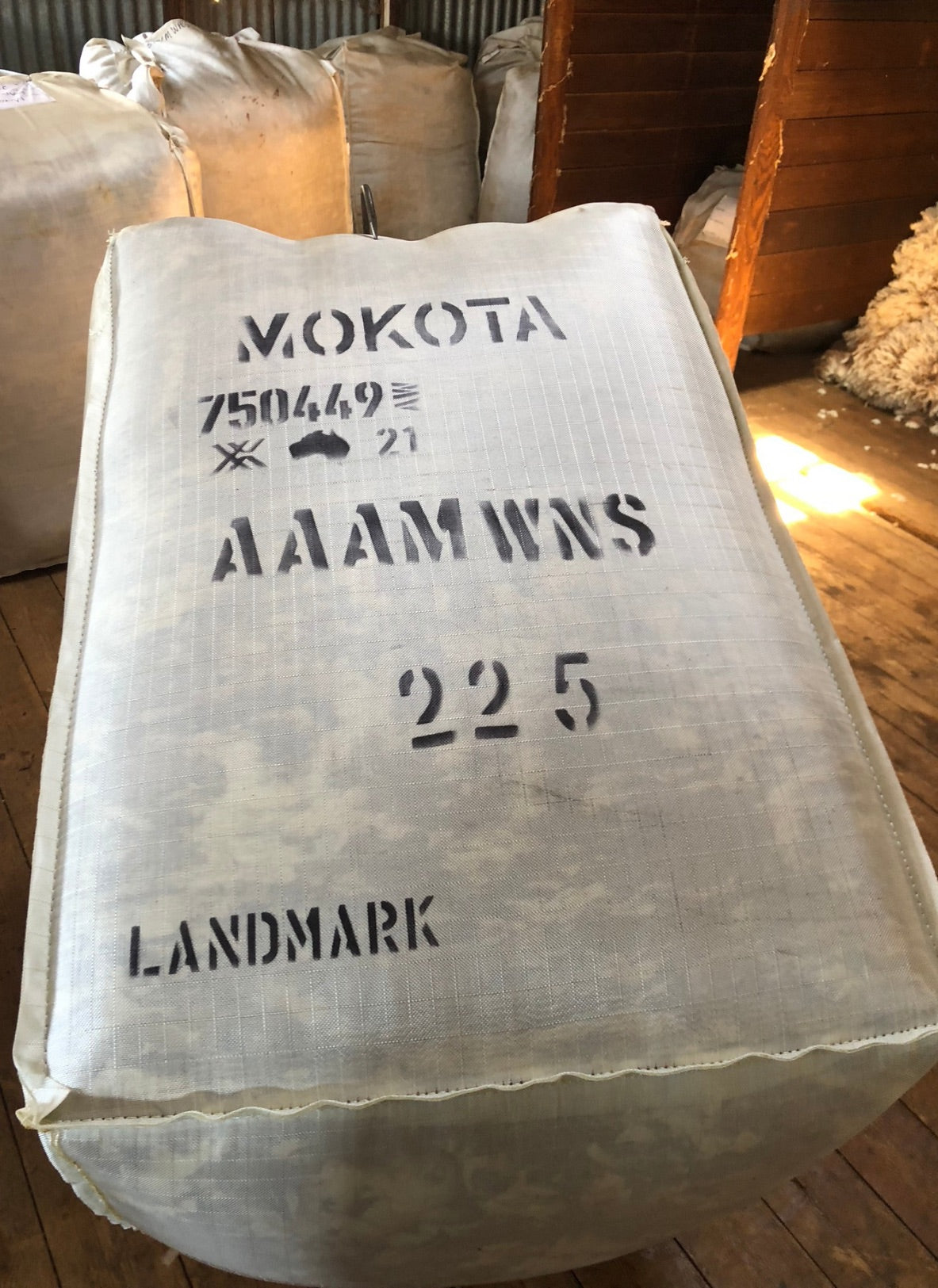 Large white bag with black text on a wooden floor
