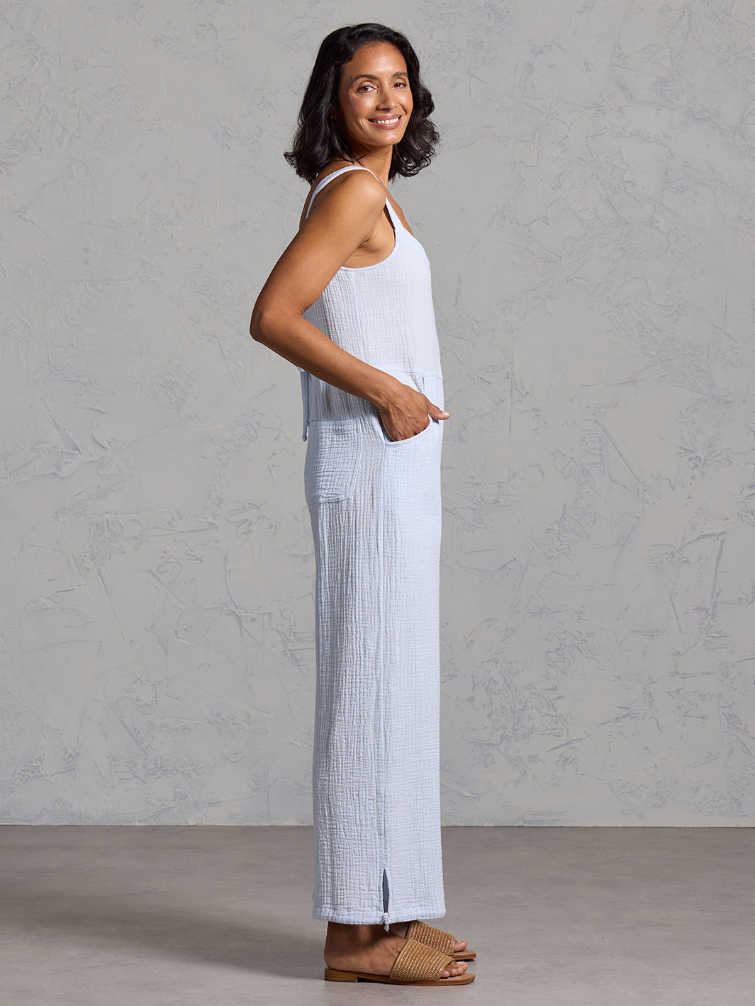 A woman wearing a serene blue cotton jumpsuit from Nomad the Label