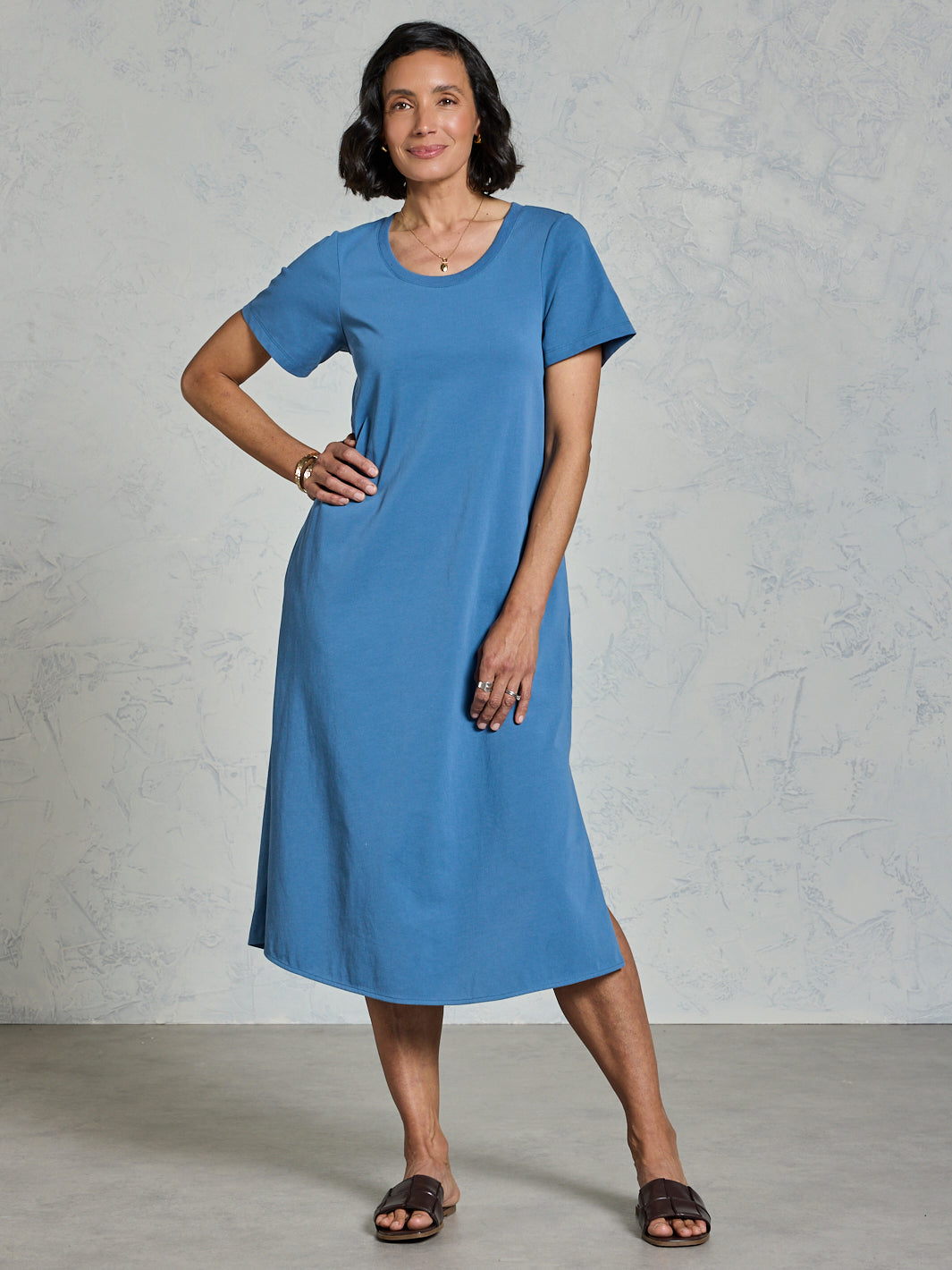Woman wearing a blue dress against a plain background