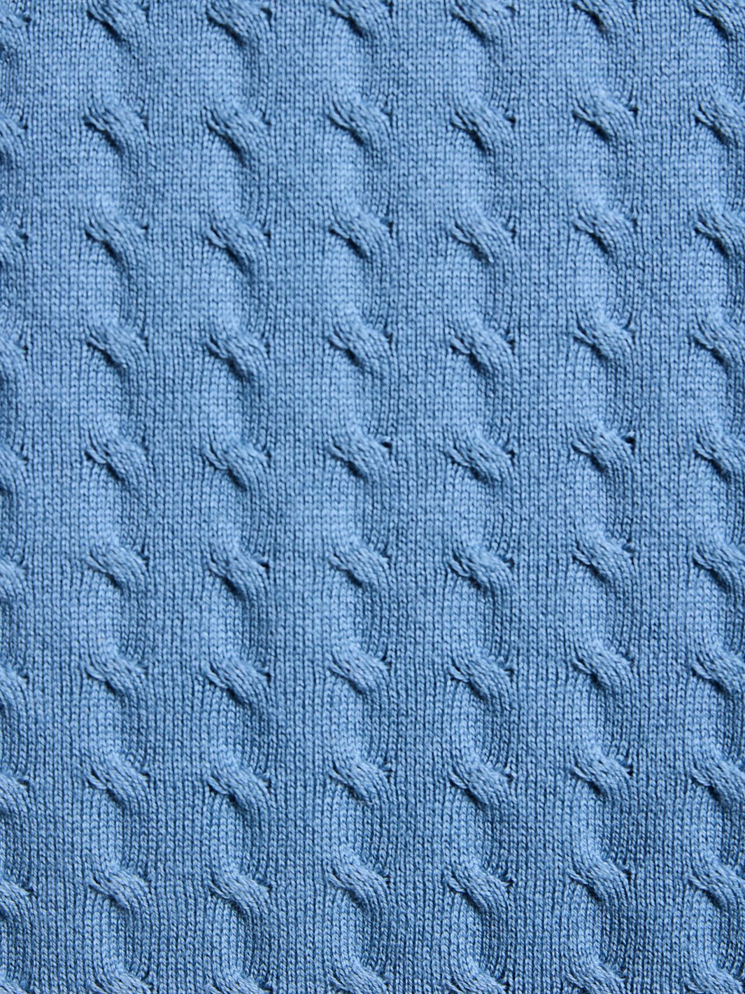 Close-up of a blue textured fabric with cable knit pattern