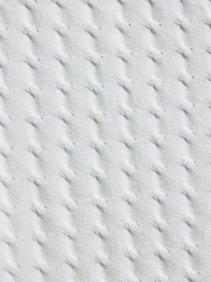 Close-up of textured light gray fabric with diagonal stitching pattern