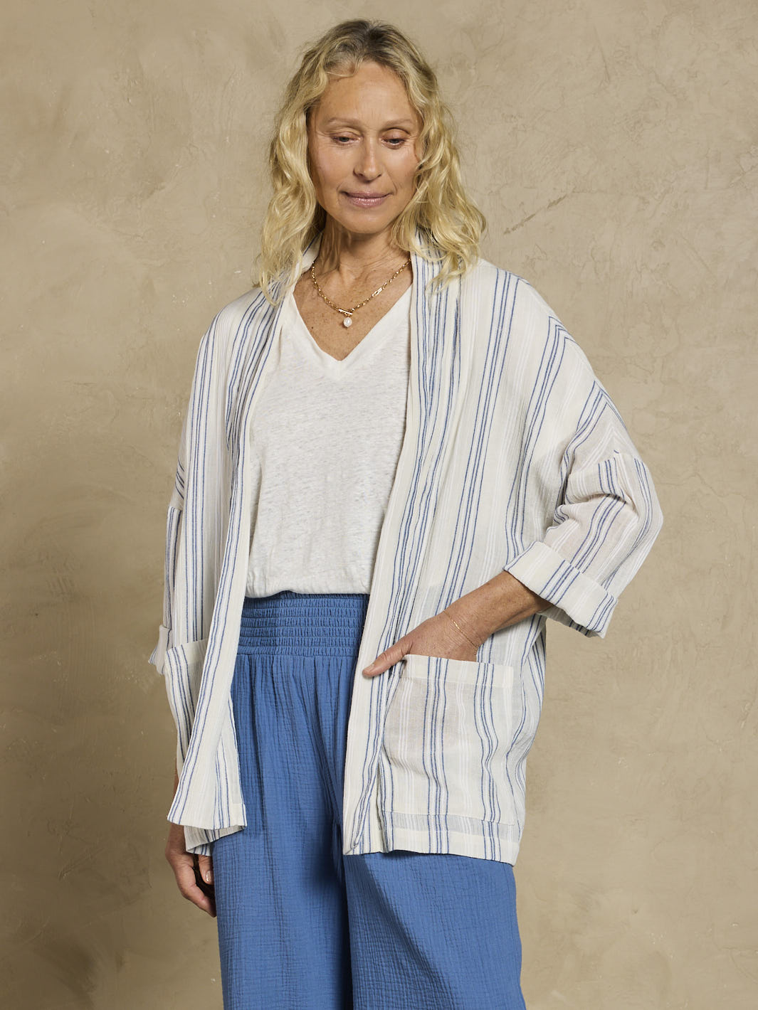 Woman wearing a white and blue cotton jacket and blue cotton pants.