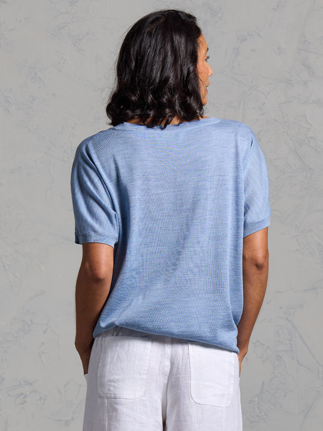 A woman wearing Toscana Merino Wool Top Sea Blue and Sadhu French Linen Pants White