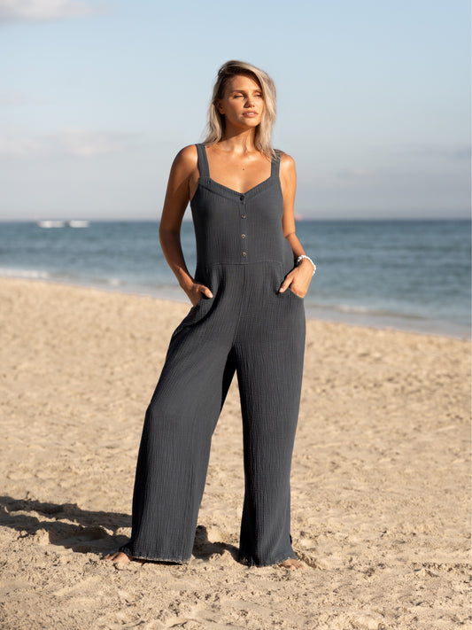 A woman wearing a charcoal cotton jumpsuit from Nomad the Label