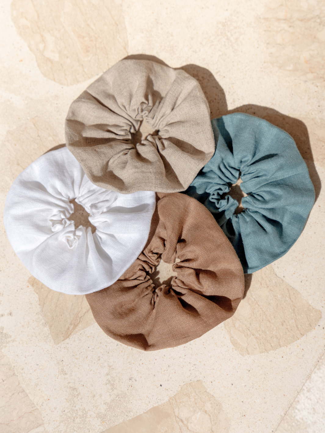 Image features Jumbo Linen Scrunchie in Tahiti Blue, Flax, Cinnamon and White.