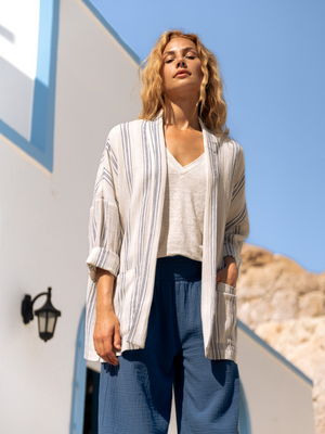 Woman wearing a white and blue cotton jacket and blue cotton pants.