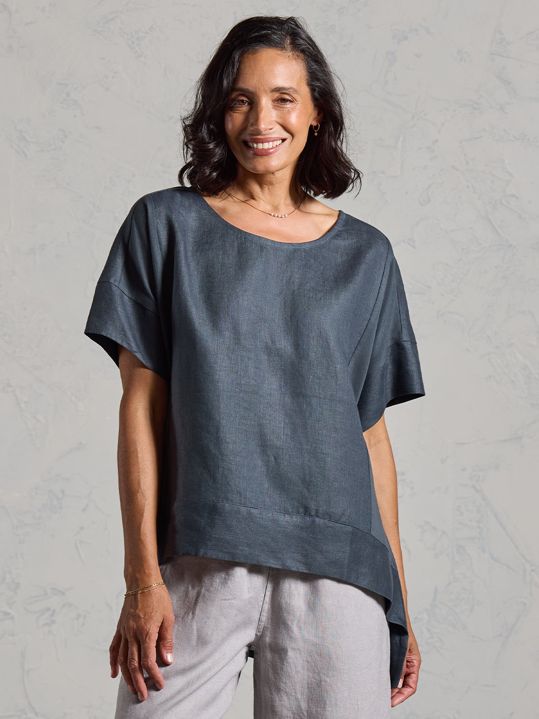Woman wearing a dark top on a gray background