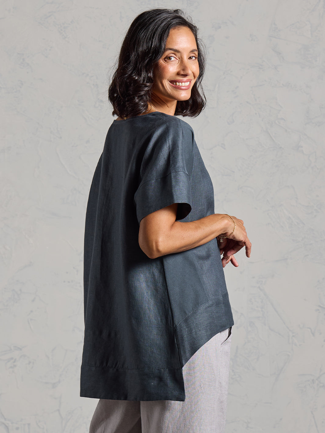 Woman wearing a dark top on a gray background