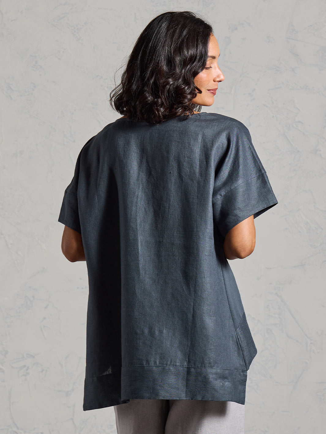 Woman wearing a dark top on a gray background
