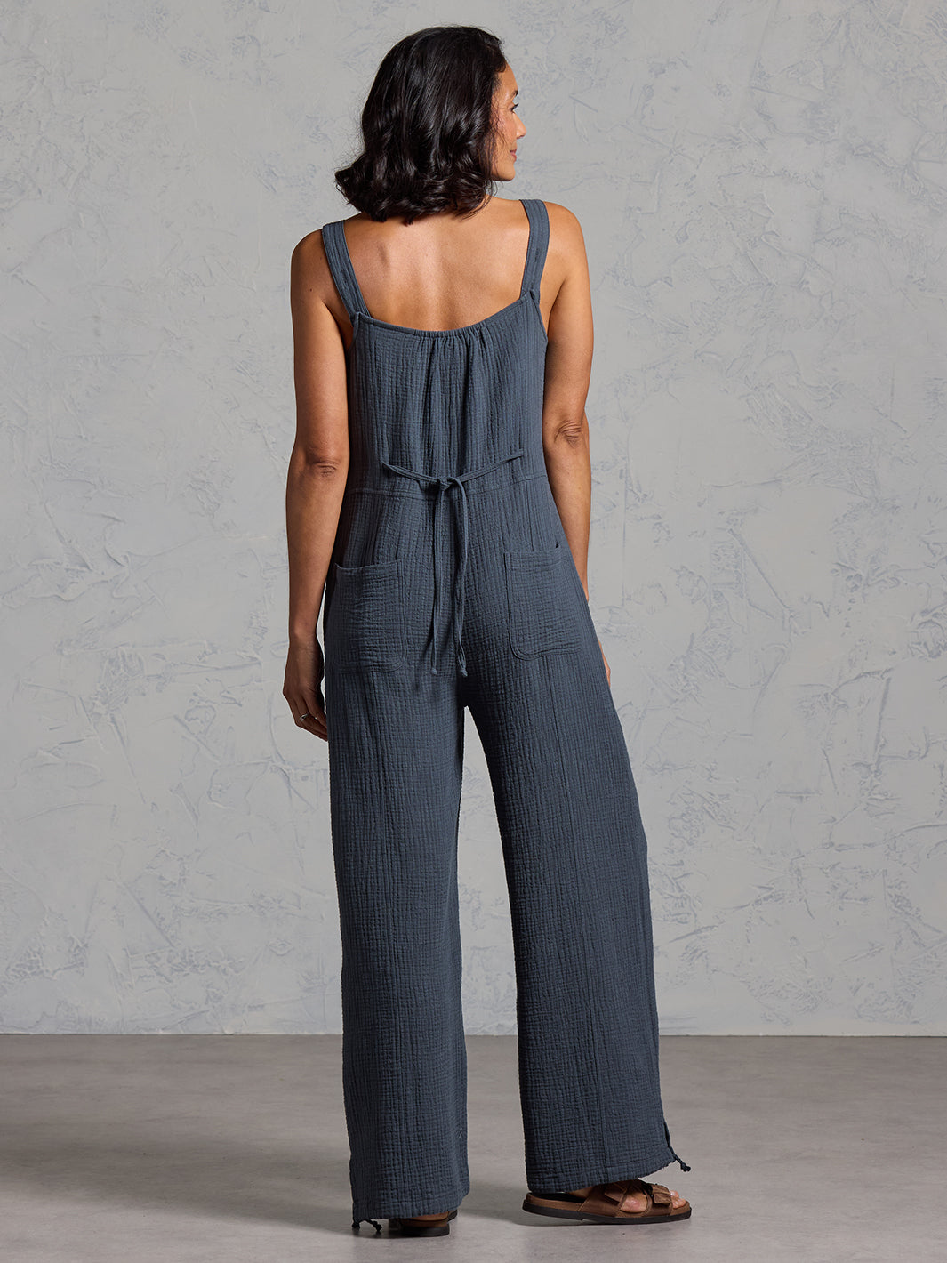 A woman wearing a charcoal cotton jumpsuit from Nomad the Label