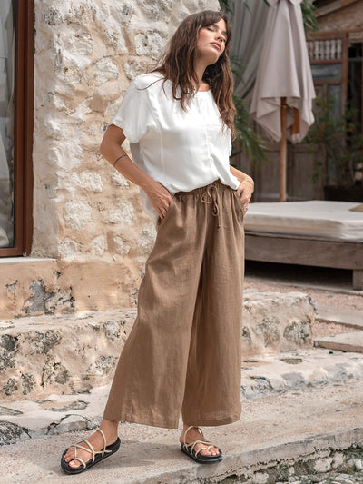 Model is wearing Gaia Linen Pants in Desert Sand