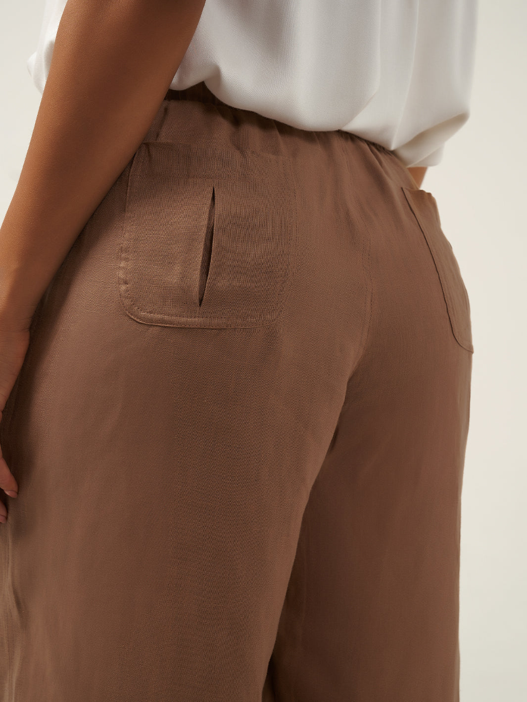 Model is wearing Gaia Linen Pants in Desert Sand