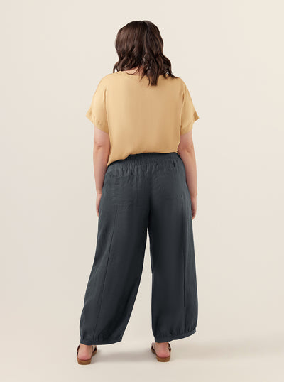 Model wears Sadhu French Linen Pants Regular in Charcoal.