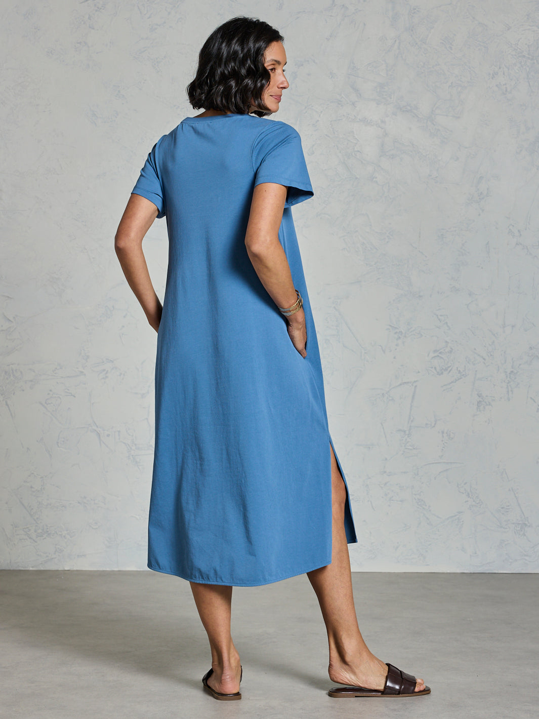 Woman wearing a blue dress with a plain background