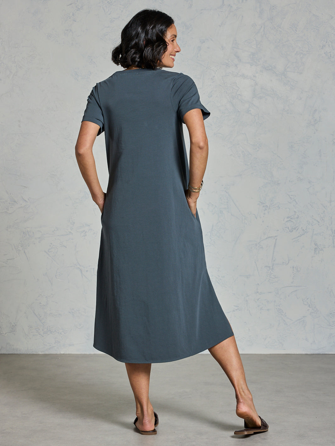Woman wearing a gray dress against a plain background