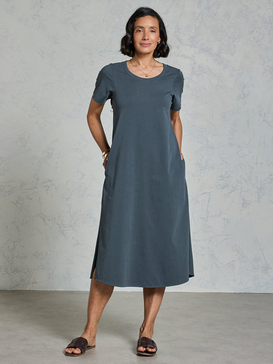 Woman wearing a gray dress against a plain background