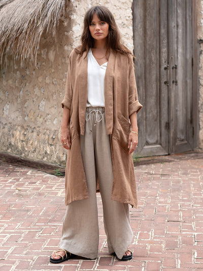 Model is wearing Nova Longline Linen Coat in Desert Sand