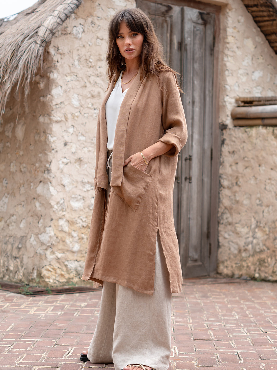 Model is wearing Nova Longline Linen Coat in Desert Sand