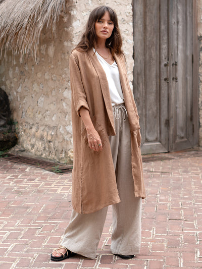 Model is wearing Nova Longline Linen Coat in Desert Sand