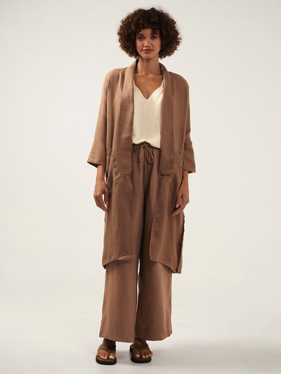 Model is wearing Nova Longline Linen Coat in Desert Sand