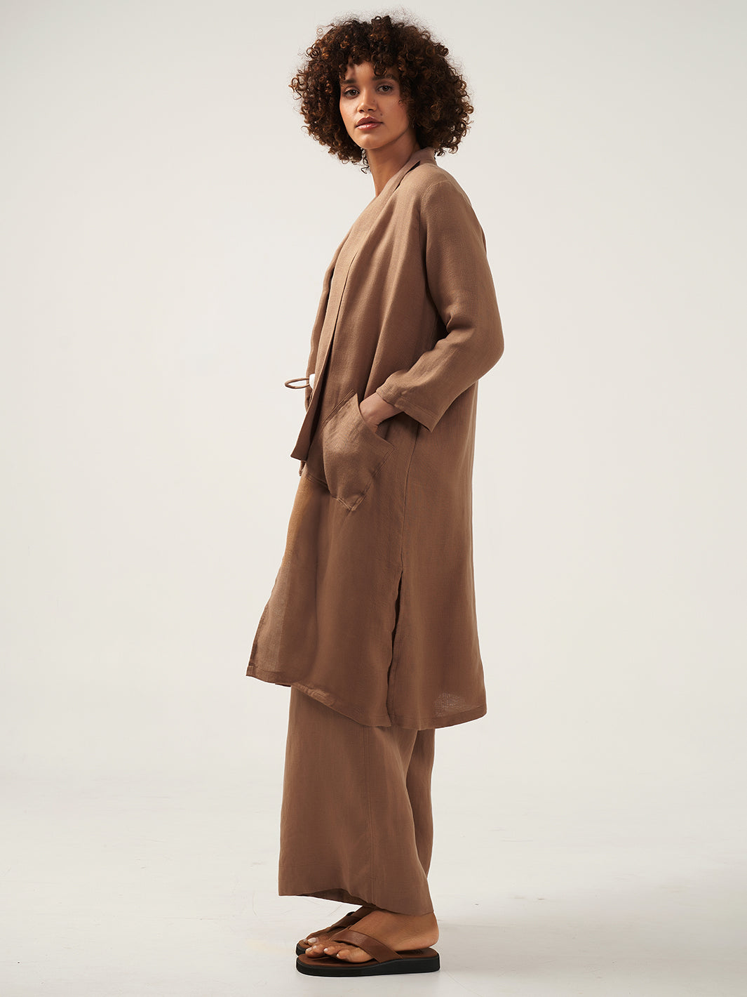 Model is wearing Nova Longline Linen Coat in Desert Sand