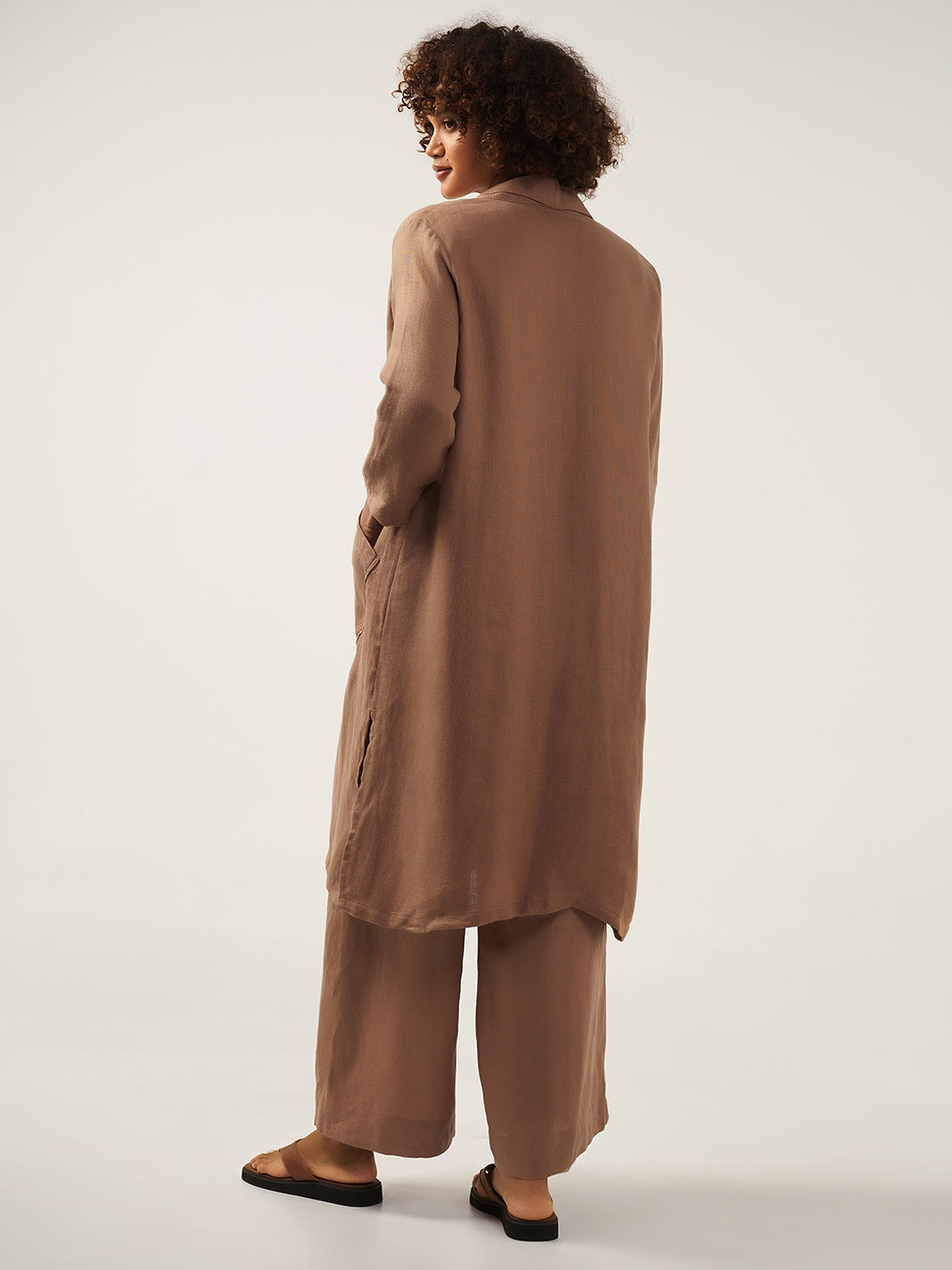 Model is wearing Nova Longline Linen Coat in Desert Sand