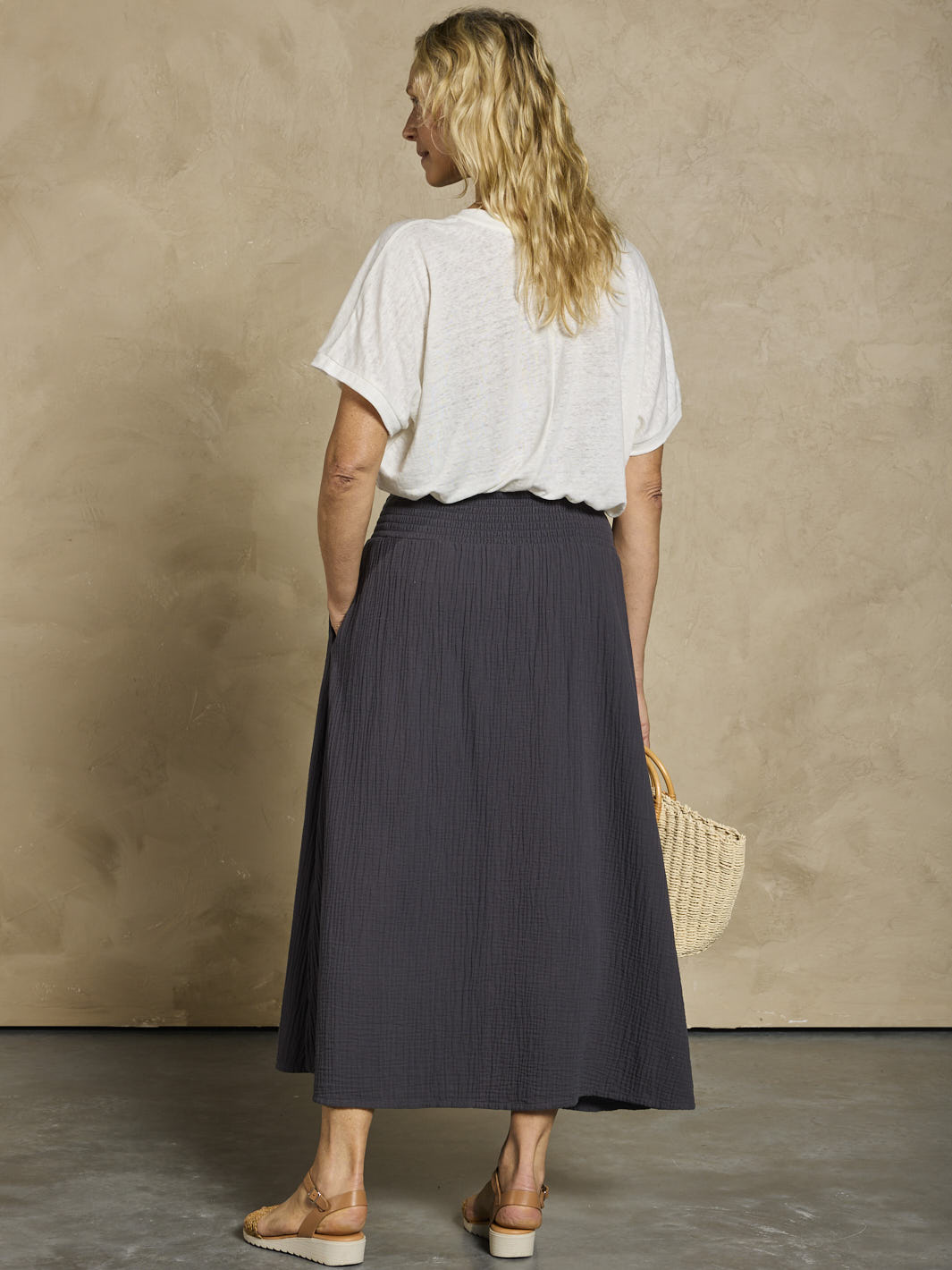 Woman in a white linen top and black cotton skirt 
