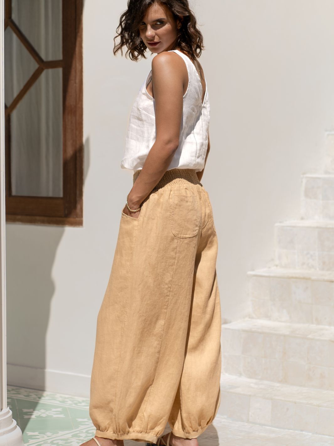 Model wears Sadhu French Linen Pants in Sand