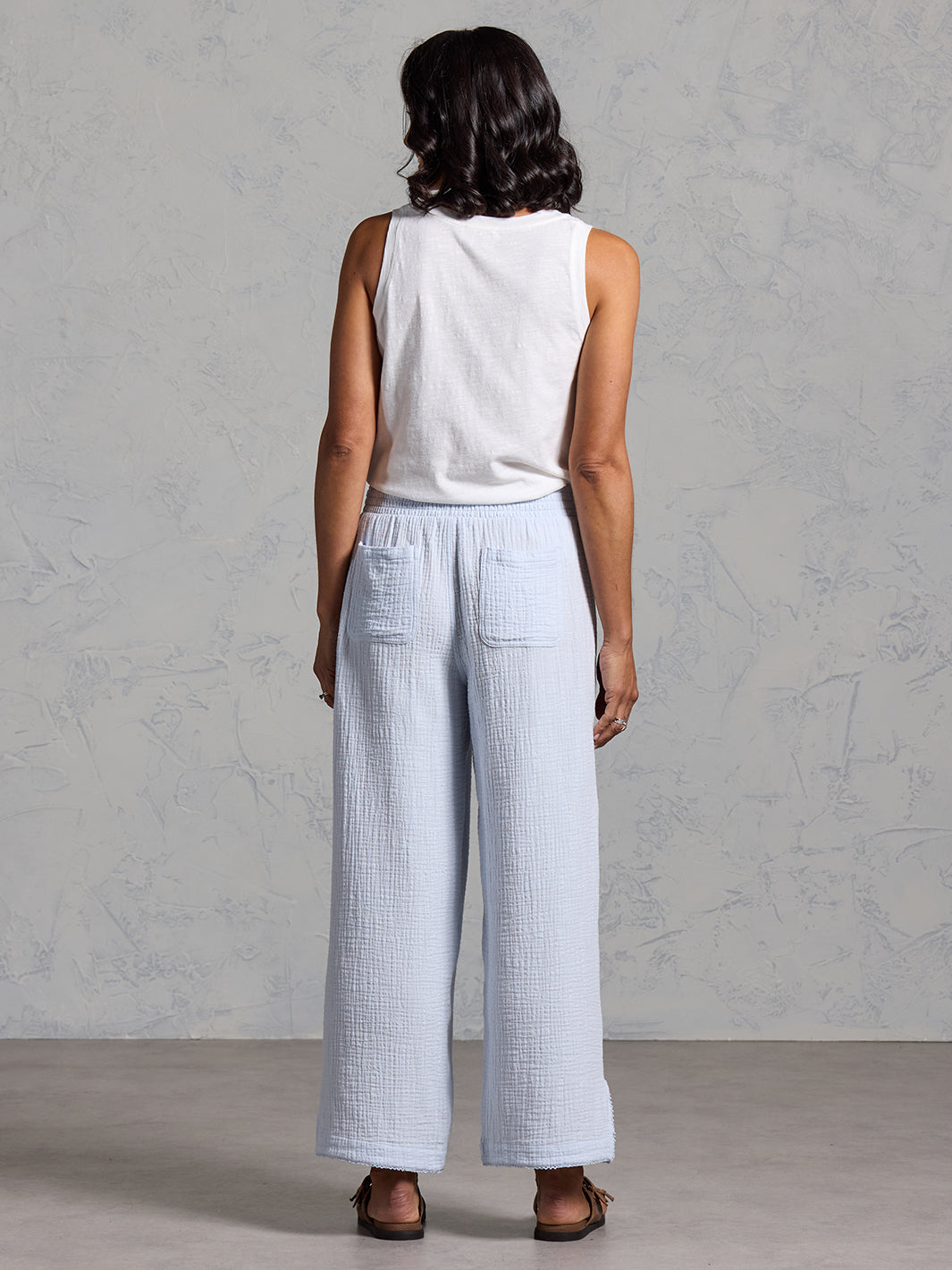 A woman wearing Sur Mer Organic Cotton Pants Serene Blue and Yarra Cotton Top Coconut from Nomad the Label