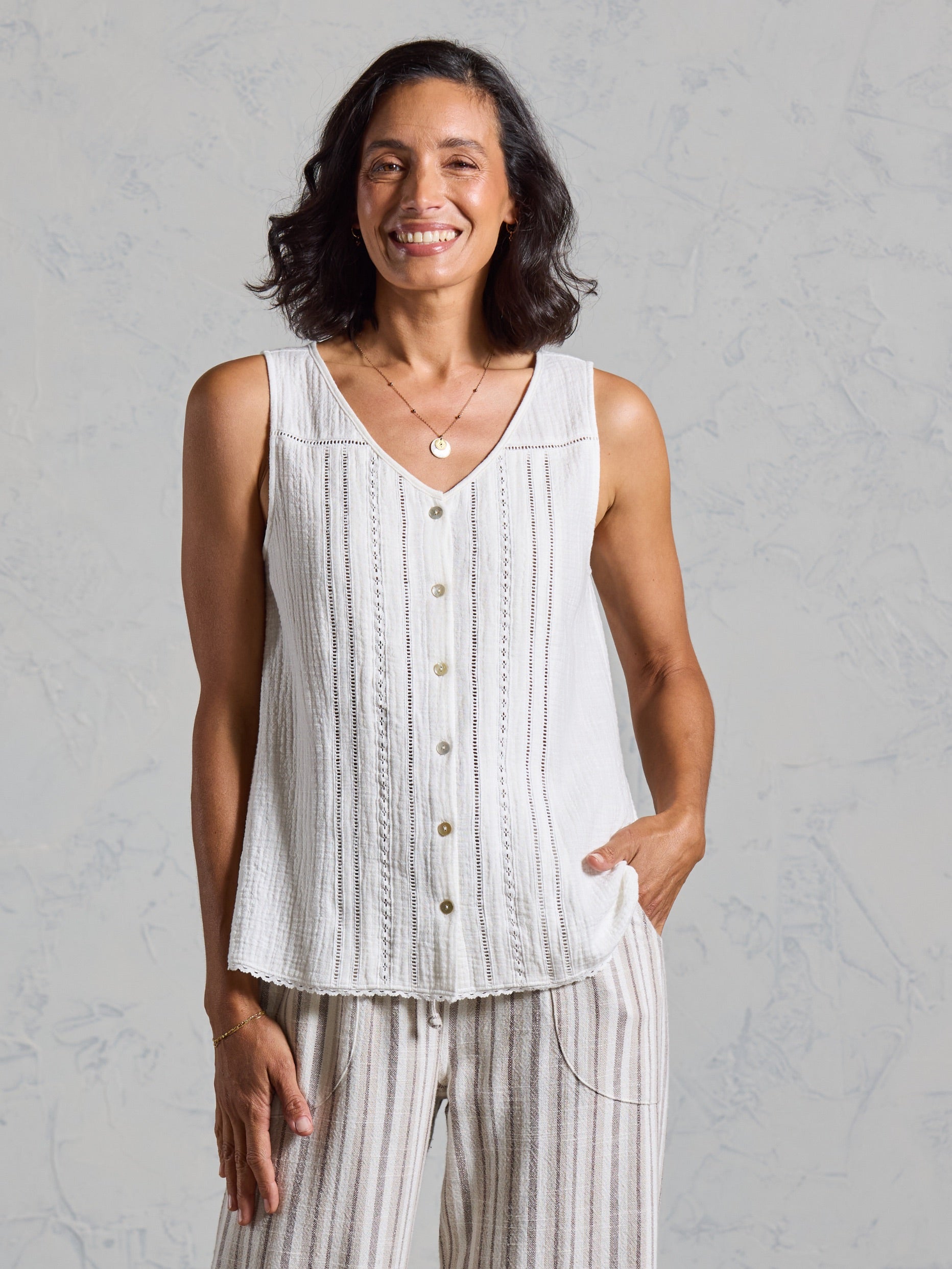 Front view of the Ceres Organic Cotton Top in coconut, worn with striped linen pants.