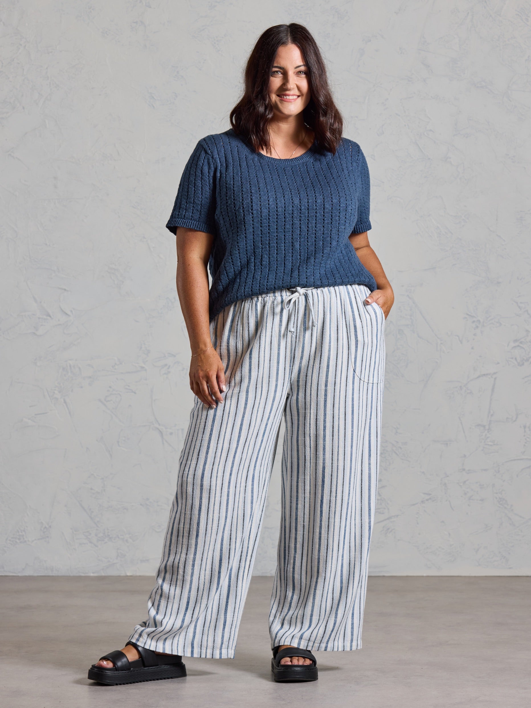 Curve model in the Jolie Linen Blend Pants in coastal blue, styled with a navy knit top.