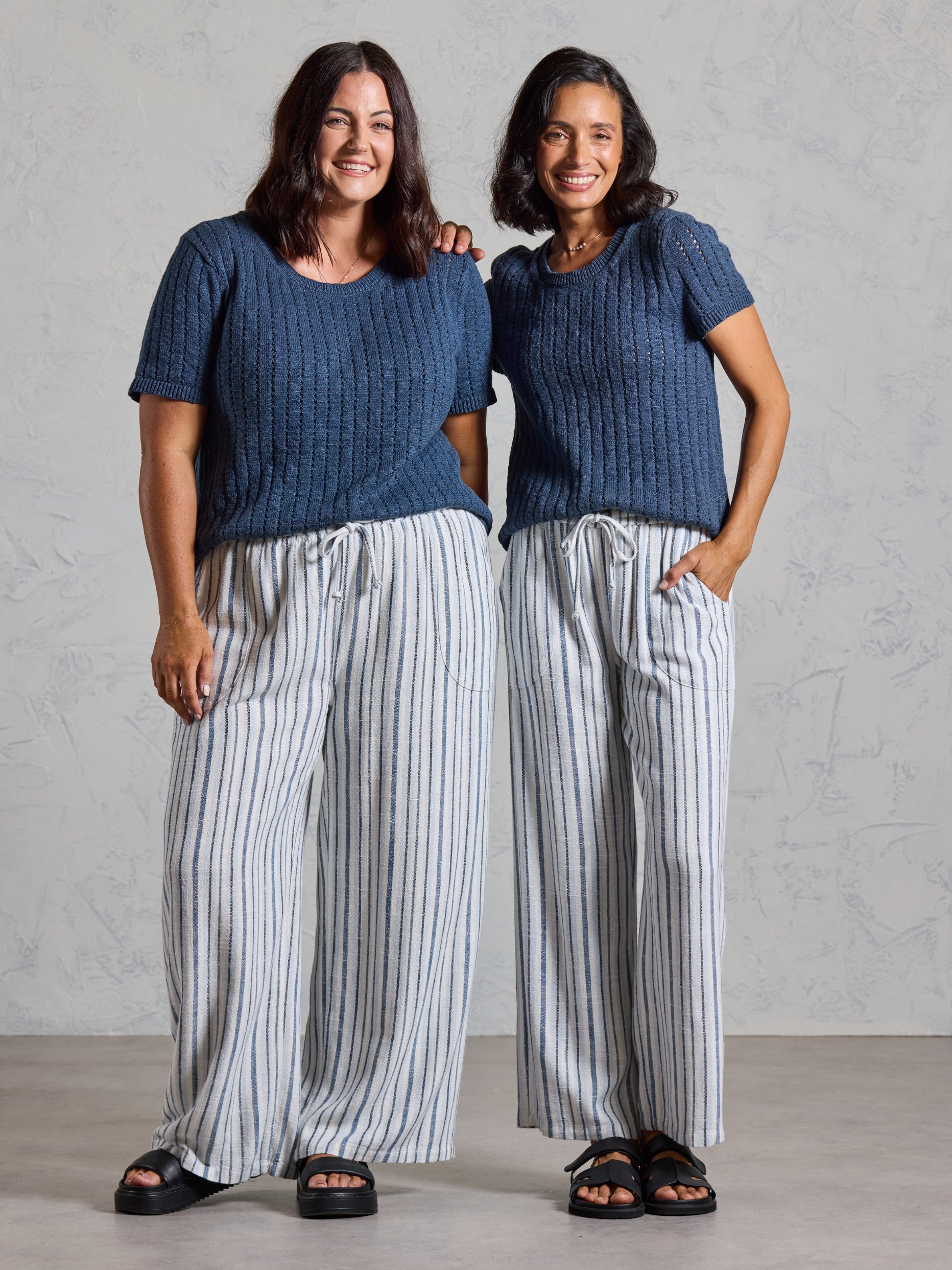 Two models wearing the Jolie Linen Blend Pants in coastal blue with navy knit tops