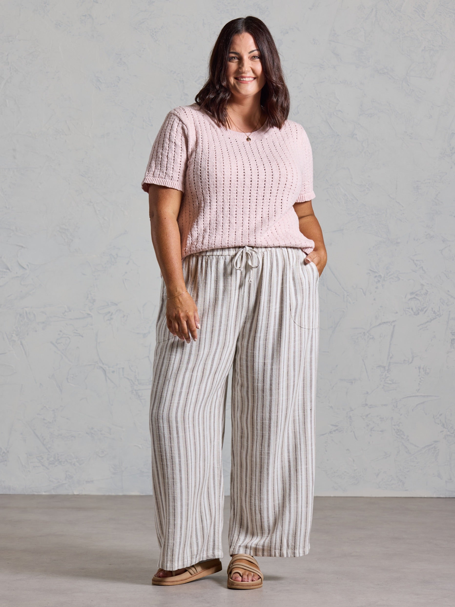 Curve model in the Jolie Linen Blend Pants in driftwood, styled with a pink knit top.